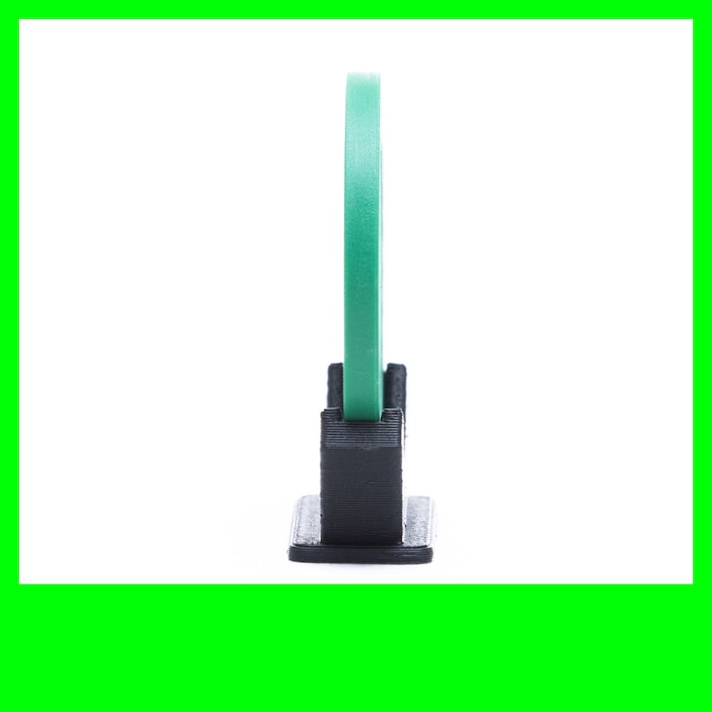 Image of the side profile of a black 3d printed display stand for poker chips and sobriety coins.  Display is holding a green poker chip.