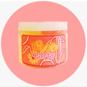May include: A clear glass jar with a yellow and orange slime inside. The jar has a white lid and a label that says "Whimsy Party".