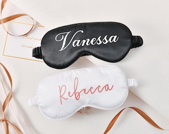 Puede incluir: Dos antifaces para dormir personalizados, uno negro con texto blanco que dice "Vanessa" y uno blanco con texto rosa que dice "Rebecca".