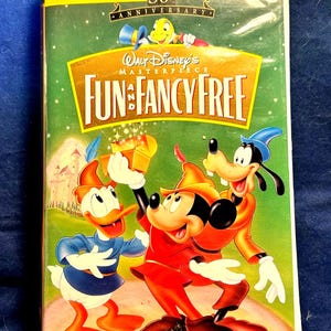 May include: A Walt Disney's Masterpiece Fun and Fancy Free VHS tape featuring a 50th Anniversary Limited Edition cover. The artwork displays Donald Duck, Mickey Mouse, and Goofy in colorful outfits, with Jiminy Cricket above the title text.