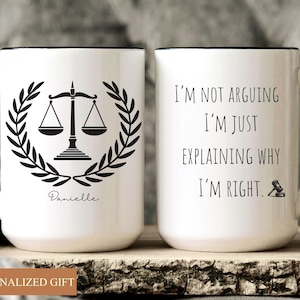 May include: White ceramic mug with black handle and rim. One side features a black scale of justice design within a laurel wreath and the name "Danielle". The other side reads "I'M NOT ARGUING I'M JUST EXPLAINING WHY I'M RIGHT."
