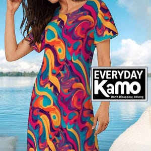 May include: A short-sleeved dress with a vibrant, abstract pattern in shades of pink, purple, orange, and teal. The dress features a round neckline and a flowing silhouette. The text "EVERYDAY Kamo" is displayed in a black box.