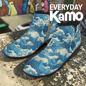 May include: A pair of ankle boots with a blue and white wave pattern. The boots have a side zipper with a gold-colored pull and a black sole. The text "EVERYDAY Kamo" is displayed in white.