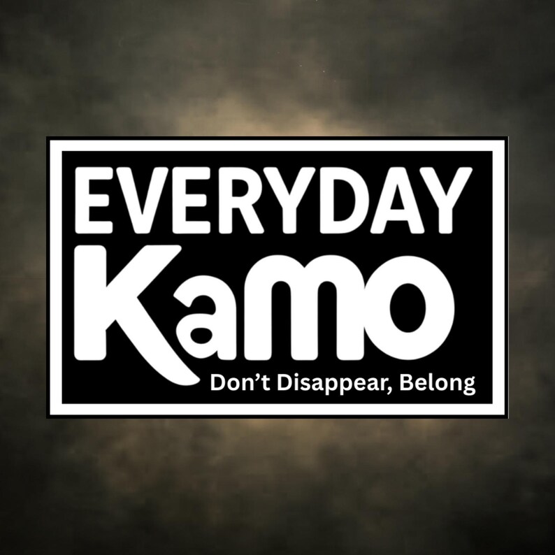 Peut inclure: Graphique rectangulaire noir et blanc avec le texte "EVERYDAY Kamo" en lettres blanches grasses. En dessous, en plus petit, "Don't Disappear, Belong". Le fond est un d&eacute;grad&eacute; de gris fonc&eacute;.