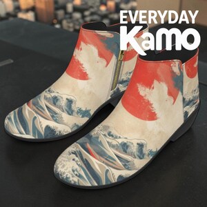 May include: A pair of ankle boots with a Japanese wave and sun design. The boots feature a cream-colored background with a red sun and blue and white waves. The boots have a side zipper and the text "EVERYDAY Kamo" is visible.