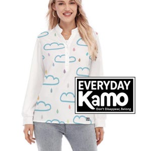 May include: White long-sleeve shirt with a whimsical cloud and raindrop pattern in blue, yellow, and purple. The shirt has a button-up collar and the text "EVERYDAY Kamo Don't Disappear, Belong" in a black rectangle.
