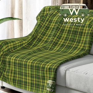 May include: Green and yellow plaid throw blanket draped over a white couch. The blanket has a subtle sheen and is soft to the touch. The blanket is made of a high-quality fabric and is perfect for adding a touch of warmth and style to any room.