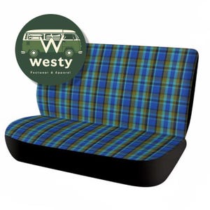 May include: A vehicle seat with a blue, green, and brown plaid pattern. The seat has a black base and back. A green circular logo with a white van and the word "westy" is in the upper left corner. The text "Footwear & Apparel" is below the word "westy".