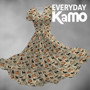 May include: A beige short-sleeved wrap dress featuring a repeating pattern of black cats, orange pumpkins, and bats within rectangular frames. The text "EVERYDAY Kamo" is displayed in white in the upper right corner of the image.