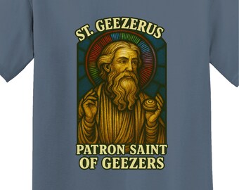 May include: Blue t-shirt featuring a graphic of St. Geezerus, the Patron Saint of Geezers. The design includes a portrait of a bearded man with a halo, set against a stained-glass style background. The text "ST. GEEZERUS" and "PATRON SAINT OF GEEZERS" are displayed.