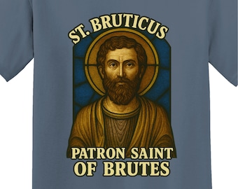 May include: Blue t-shirt featuring a graphic of a saint with a beard, surrounded by a gold halo and stained-glass window design. The text reads "ST. BRUTICUS" and "PATRON SAINT OF BRUTES". The brand name "FakeSaintShop" is at the bottom.