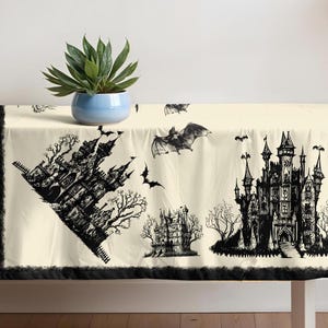 May include: A cream-colored Halloween-themed tablecloth featuring black illustrations of haunted castles, bats, and trees. The tablecloth has a black border and is suitable for a festive dining experience.