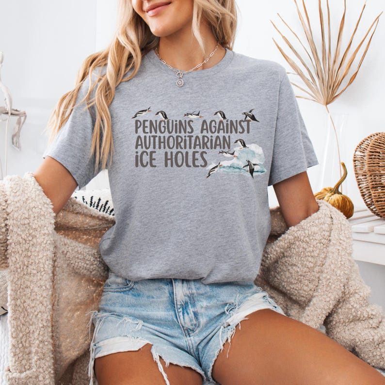 Make a bold (and chilly) statement with this hilarious penguin protest tee! Featuring the phrase “Penguins Against Authoritarian Ice Holes” in bold font, this shirt shows penguins standing proud above the text and perched on a floating chunk of ice. It’s perfect for protests, marches, or any day you feel like calling out cold-hearted nonsense. Available in 7 colors, it's a comfy, conversation-starting way to stand up (or waddle) for what’s right.