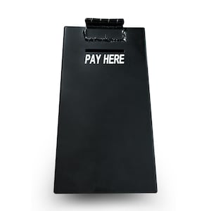 May include: A black metal donation box with a slot at the top and the words "PAY HERE" in white. The box has a hinged lid and a rectangular shape, ideal for collecting payments or donations.