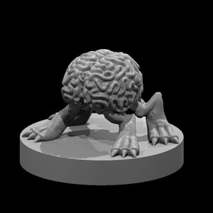 May include: A gray 3D-printed figurine of a brain with legs and feet, posed on a circular platform. The brain is detailed with realistic folds and ridges. The creature's feet have sharp claws, and the background is black.