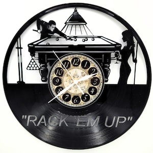May include: Black vinyl record clock featuring a billiards scene. The clock face is in the center, with a vintage design. The words "RACK 'EM UP" are etched at the bottom. The clock shows a man playing pool and a woman holding a glass.