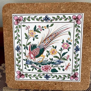 May include: Square ceramic tile with a colorful bird and floral design, set on a cork coaster. The tile features a pheasant with red, green, and yellow plumage, surrounded by pink, blue, and yellow flowers.