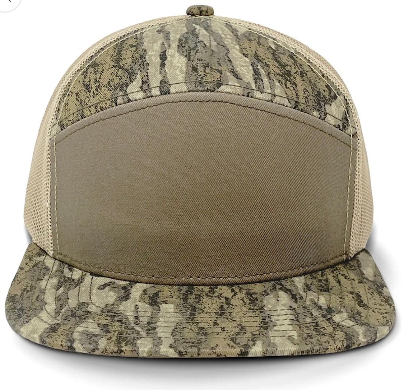 Op de afbeelding: Een bruine en beige camouflage baseballpet met een mesh achterkant en een effen bruin voorpaneel. De pet heeft een gebogen klep.