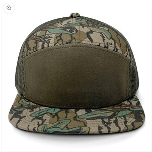 May include: A green and brown camouflage trucker hat with a solid green front panel. The hat has a mesh back and a curved brim.