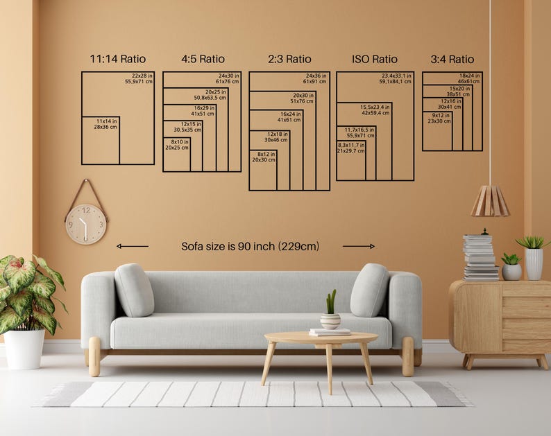 May include: A room interior featuring a light gray sofa, a wooden coffee table, and a wooden side table. The wall displays various rectangular frame sizes, with measurements in inches and centimeters, and the text "Sofa size is 90 inch (229cm)".