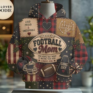 May include: A pullover hoodie featuring a patchwork design with red and black plaid, football-themed graphics, and text including "FOOTBALL MOM," "LOUD PROUD & UNSTOPPABLE," "SOME PEOPLE ONLY DREAM OF MEETING THEIR HERO I RAISED MINE," and "GAME DAY."