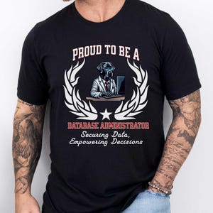 May include: Black t-shirt with a graphic of a dog wearing glasses and a suit, working on a computer. Text reads "PROUD TO BE A DATABASE ADMINISTRATOR Securing Data, Empowering Decisions."