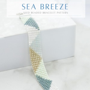 Puede incluir: Primer plano de un brazalete de cuentas con un patrón geométrico en tonos azules, blancos y dorados. El brazalete está sobre una superficie blanca y el texto "SEA BREEZE SEED BEADED BRACELET PATTERN" está por encima del brazalete. El texto "AWAKEN YOUR STYLE" está debajo del brazalete.