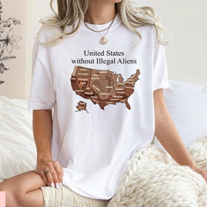 May include: White t-shirt featuring the text "United States without Illegal Aliens" above a map of the United States. The map is shaded in various shades of brown. The shirt is a casual style.