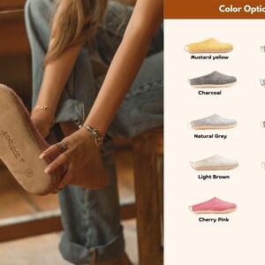 A person wearing indoor slippers, shown alongside a range of available colors including mustard yellow, jungle green, charcoal, denim, natural grey, natural brown, light brown, lavender, cherry pink, and baby pink.