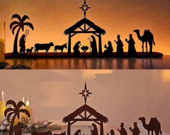May include: A wooden nativity scene silhouette. The scene includes a palm tree, animals, a stable with a star, and figures representing the holy family and the three wise men. The figures are all in dark brown.