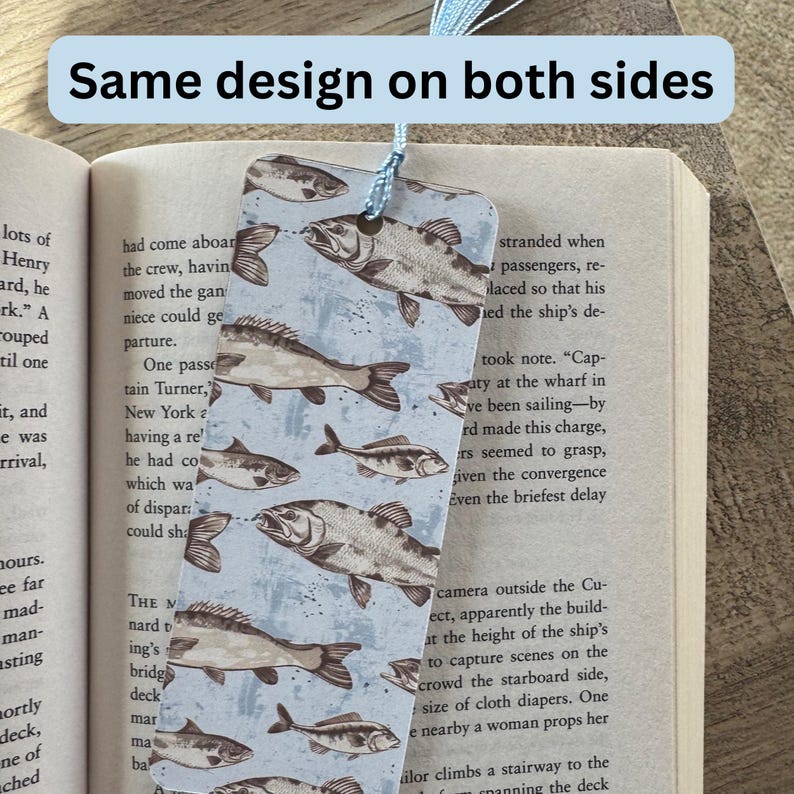 May include: A blue bookmark with a pattern of brown fish on a light blue background. The bookmark has a blue tassel.