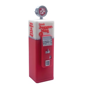 Può includere: Un distributore di bevande rosso e bianco con la scritta "Drink Juggernog". Il distributore ha un corpo rosso, una parte superiore bianca e un pannello di controllo rosso. In alto c'è un'emblema argentato con una croce.