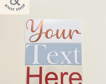 May include: Three rectangular signs with text. The top sign has the word "Your" in copper-colored script. The middle sign has the word "Text" in white block letters on a light blue background. The bottom sign has the word "Here" in red block letters.
