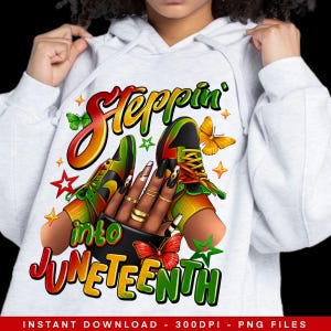 May include: A white hoodie with a graphic design featuring a hand holding two trainers with the text "Steppin' into Juneteenth" in colourful lettering.