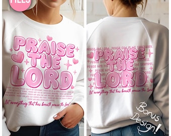 May include: White sweatshirt with a pink graphic design that says "Praise the Lord" with hearts and stars. The back of the sweatshirt has the same design with the addition of a Bible verse.