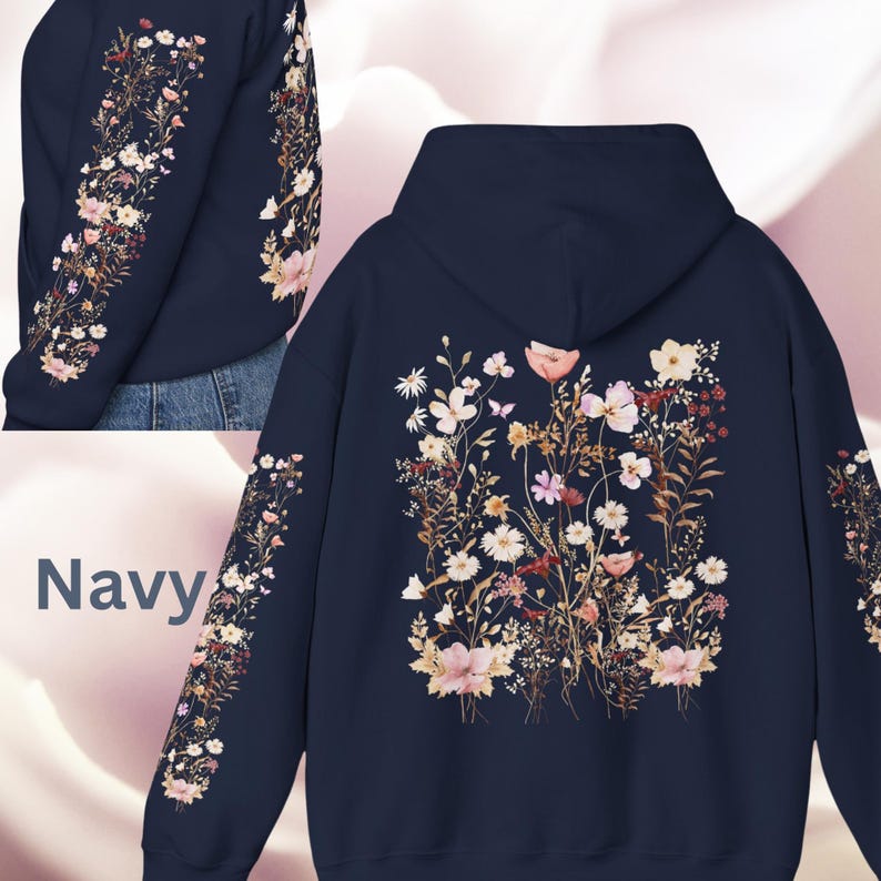Pu&ograve; includere: Felpa con cappuccio blu navy con stampa floreale sul davanti e sulle maniche. La stampa presenta una variet&agrave; di fiori e foglie in tonalit&agrave; rosa, bianco e marrone.