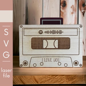 Puede incluir: Una cinta de cassette de madera con un logotipo de Spotify y el texto "Te amo".