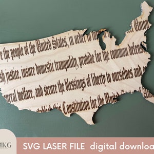 Puede incluir: Un contorno de madera de los Estados Unidos de América cortado con láser con el texto "We the people of the United States, in order to form a more perfect Union, establish justice, insure domestic tranquility, provide for the common defense, promote the general welfare, and secure the blessings of liberty to ourselves and our posterity, do ordain and establish this Constitution for the United States of America." El texto está en un estilo de fuente tradicional.