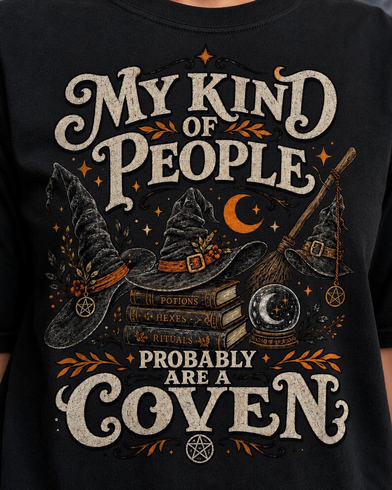May include: A black t-shirt featuring a graphic print with the text "MY KIND OF PEOPLE PROBABLY ARE A COVEN". The design includes three witch hats, a stack of books labeled "POTIONS", "HEXES", and "RITUALS", a broomstick, and a crystal ball.