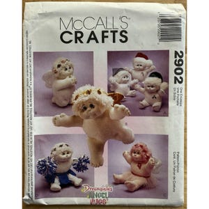 Puede incluir: Patrón de costura McCall's Crafts con varias muñecas de ángel de peluche. El patrón incluye instrucciones para hacer varios diseños de ángeles, con diferentes atuendos y poses. El paquete tiene el texto "Dreamsicles Angel Hugs".