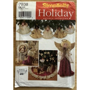 Könnte beinhalten: Eine Simplicity Holiday-Mustersammlung mit Engelsornamenten und einem Baumrock. Das Muster enthält Anweisungen zur Herstellung verschiedener Weihnachtsdekorationen, darunter Engelspuppen mit goldenen und weißen Kleidern und einem bordeauxfarbenen Baumrock.