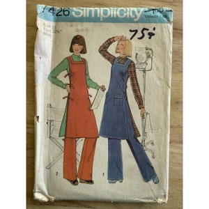 以下が含まれることがあります： ヴィンテージ Simplicity の裁縫パターン、サイズ 10、エプロンとパンツを着用した 2 人の女性のイラストが特徴です。パターンには「Simplicity」と「Miss」の文字が含まれています。カバーは古く、摩耗が見られます。