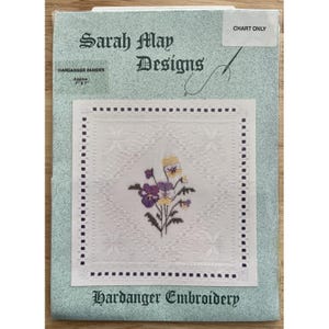 May include: A Hardanger embroidery chart with a pansies design. The central square features a floral motif with purple and yellow pansies. The chart is labelled "Sarah May Designs" and "Hardanger Embroidery". The approximate size is 17.78cm x 17.78cm.