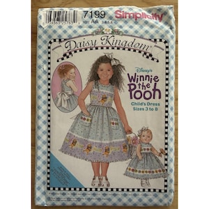 May include: A Simplicity sewing pattern for a child's dress featuring Disney's Winnie the Pooh. The pattern includes sizes 3 to 8. The package has a blue and white checkered border and shows a drawing of a girl wearing the dress.