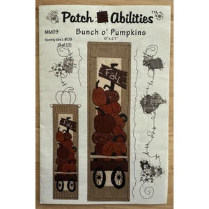 Könnte beinhalten: Ein Bastelmuster mit dem Titel "Bunch o' Pumpkins" mit dem Text "Fall" auf einem Schild. Das Design zeigt einen Stapel Kürbisse in einem Wagen. Das Muster misst 15 cm x 53 cm.