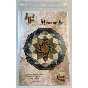May include: A package featuring a Moroccan Tile design. The design is an intricate geometric pattern in shades of brown, tan, and black. The text "Jewel Box Moroccan Tile" is visible, along with "Gems 5 & 10".