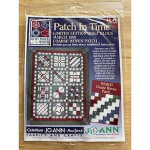 Op de afbeelding: Een Patch In Time Limited Edition Quilt Block March 1998 Coarse Woven Patch set in een doorzichtige plastic zak. De verpakking bevat tekst, een illustratie van een quiltblok van 31,75 cm bij 31,75 cm en logo's van Cloth World en Jo-Ann.