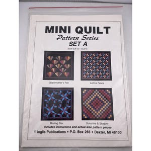 May include: A clear plastic bag containing a pattern set for mini quilts. The cover reads "MINI QUILT Pattern Series SET A." Four quilt designs are shown: Grandmother's Fan, Lattice Fence, Blazing Star, and Sunshine & Shadow. Each quilt is 22 inches square.