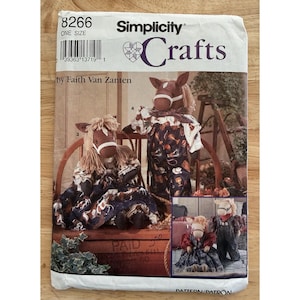 Könnte beinhalten: Simplicity Crafts Schnittmuster 8266, mit Designs für pferdebezogene Stofftiere. Das Schnittmuster enthält Anleitungen zum Erstellen von Plüschpferden mit verschiedenen Outfits. Das Cover zeigt Bilder der fertigen Bastelarbeiten, die die Pferdepuppen zeigen.