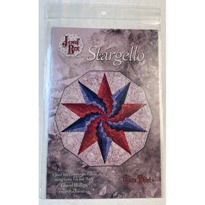 Puede incluir: Un paquete de patrón de costura "Stargello". El diseño presenta un patrón de estrella en rojo y azul. El texto incluye "Jewel Box" y "Gem Thirty". El patrón es de Cheryl Phillips.